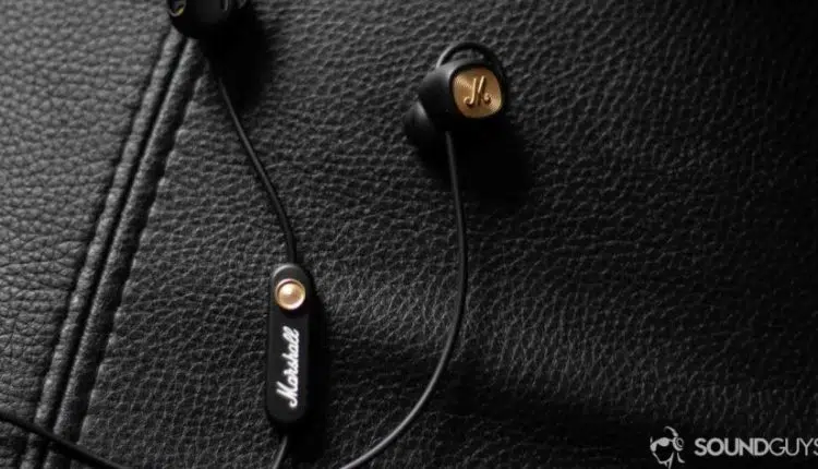 Marshall Minor II wireless earbuds in black on leather surface.