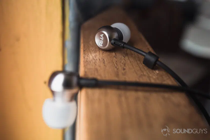 Samsung Galaxy S10 headphone: Close-up of RHA MA390 earbuds on a wooden beam.