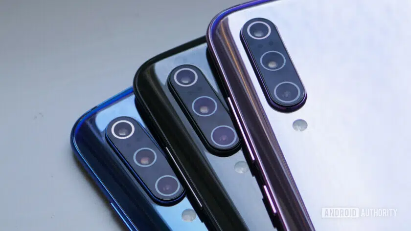 Photo of three different colored Xiaomi Mi 9 smartphones focusing on the back three triple cameras.